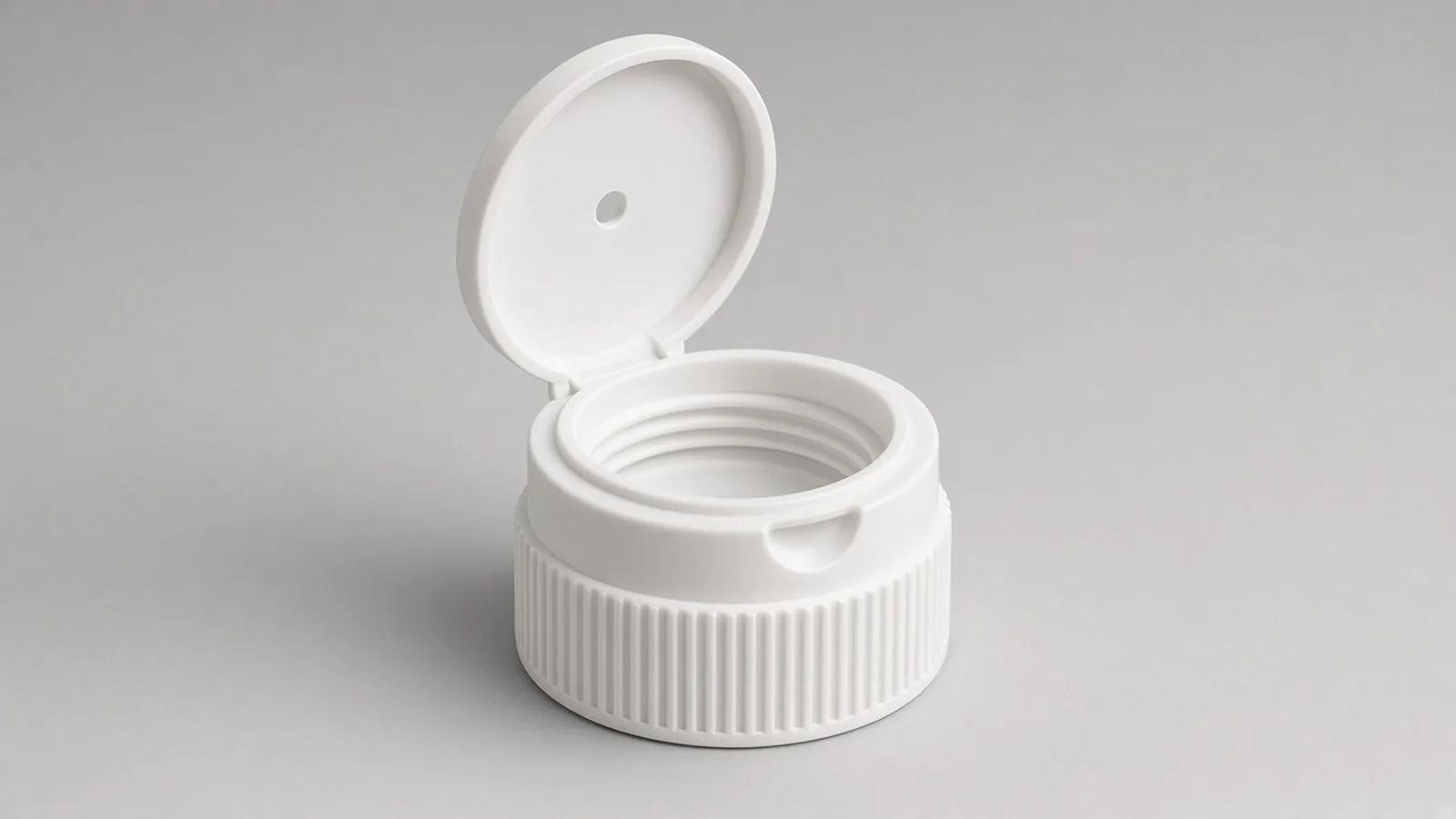 Open white disc top cap showing the orifice, hinge, finger recess and ribbed skirt